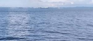 a large body of water with a ship in the distance at Bulan madu in Alor Setar