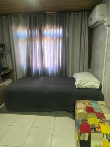 um quarto com uma cama e uma janela em Pousada Tia Moni em Blumenau