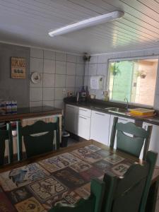 uma cozinha com mesa e cadeiras e um balcão em Pousada Tia Moni em Blumenau