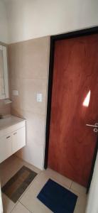 a red door in a bathroom with a sink at HERMOSA CASA 2 DORMITORIOS EN POTRERO DE GARAY in Potrero de Garay