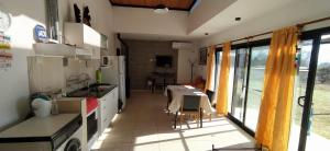 a kitchen with a table and a dining room at HERMOSA CASA 2 DORMITORIOS EN POTRERO DE GARAY in Potrero de Garay