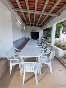einen langen weißen Tisch und Stühle auf einer Terrasse in der Unterkunft Quinta D'Avó in Setúbal