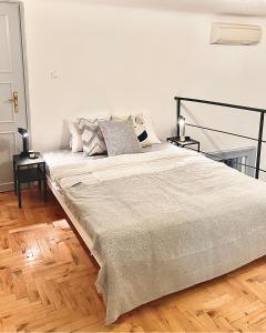 ein großes Bett in einem Schlafzimmer mit Holzboden in der Unterkunft Blue Mirror Apartment in Budapest