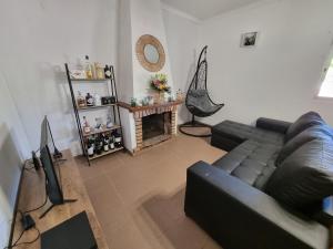 Quinta D'Avó في سيتوبال: غرفة معيشة مع أريكة سوداء ومدفأة