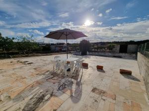 einen Tisch und Stühle mit Sonnenschirm auf einer Terrasse in der Unterkunft Quinta D'Avó in Setúbal