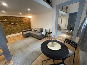ein Wohnzimmer mit einem Tisch und einem Sofa in der Unterkunft Blue Mirror Apartment in Budapest