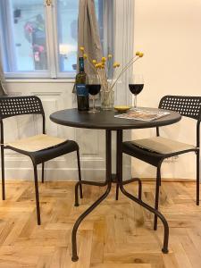 einen Tisch mit zwei Stühlen und zwei Gläsern Wein in der Unterkunft Blue Mirror Apartment in Budapest