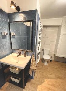 ein Badezimmer mit einem Waschbecken, einem Spiegel und einem WC in der Unterkunft Blue Mirror Apartment in Budapest