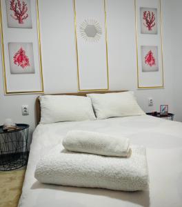 Una cama blanca con una toalla encima. en Cazare Ploiesti en Ploieşti