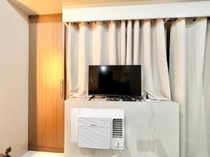 una TV sopra un frigorifero in camera di Elegant Condo Hotel across NAIA Airport Terminal 3 Newport City a Manila