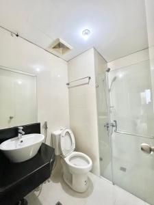 e bagno con servizi igienici, lavandino e doccia. di Elegant Condo Hotel across NAIA Airport Terminal 3 Newport City a Manila