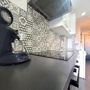 eine Küche mit schwarzen und weißen Wandfliesen in der Unterkunft Le Meney in Grenoble