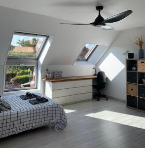 um quarto com uma cama, uma secretária e 2 janelas em La maison d’Aurélie em Pleudihen