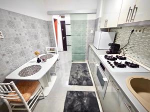 a white kitchen with a stove and a sink at Cazare Ploiesti in Ploieşti +12 photos