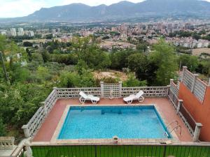 a swimming pool with chairs and a view of a city at Antica Terrazza in Terni