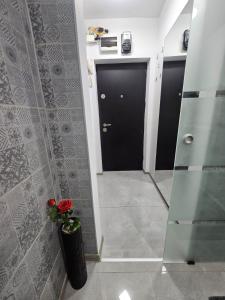 a bathroom with a black door and a vase of flowers at Cazare Ploiesti in Ploieşti