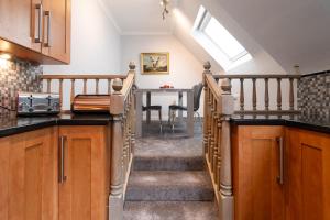 a kitchen with stairs leading up to a dining room table at The Gables Poole, 3 Bedroom Penthouse Apartment in Poole