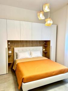 a bedroom with a large bed with white cabinets at Doctor Guest House in Tortolì