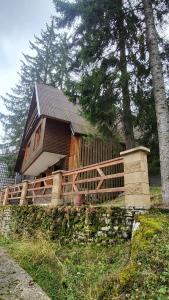 a large wooden house with a wooden fence around it at Cozy Cottage Vlašić in Vlasic