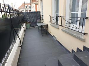 eine Terrasse mit Tisch und Stühlen auf einem Balkon in der Unterkunft cosy appartment - Clamart Percy Paris in Clamart