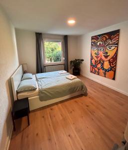 1 dormitorio con 1 cama y una pintura en la pared en ART House /15 Min. Düsseldorf Messe,Airport & City en Meerbusch