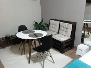 a living room with a table and chairs and a couch at Suíte 100m da praia e academia inclusa dias de semana in Maceió