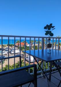 un tavolo blu su un balcone con vista sulla spiaggia di "La Sorra" Résidence en Bord de mer a Saint-Cyprien-Plage