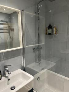 a white bathroom with a shower and a sink at Lochindaal Hotel in Port Charlotte