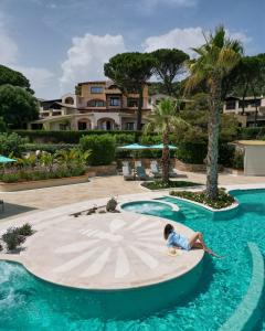 a little girl laying on a pool in a resort at Hotel Abi d'Oru in Porto Rotondo