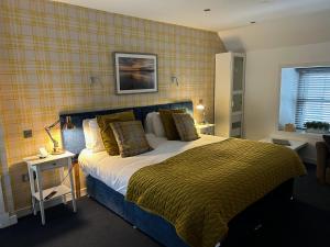 ein Schlafzimmer mit einem großen Bett mit gelber Wand in der Unterkunft Lochindaal Hotel in Port Charlotte