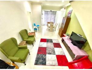 uma sala de estar com cadeiras verdes e um piso em xadrez em Daffodil Homestay in Perlis em Kangar