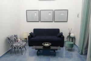 een woonkamer met een blauwe bank en een stoel bij Acquamarina in Agropoli