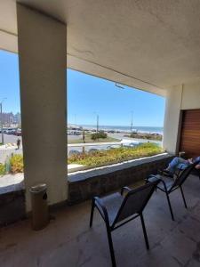 a balcony with two chairs and a view of the ocean at Edificio Punta del Este in Punta del Este