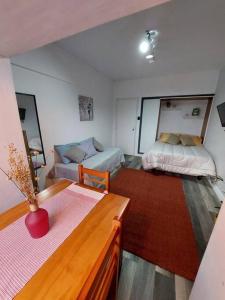 ein kleines Wohnzimmer mit einem Sofa und einem Bett in der Unterkunft Edificio Punta del Este in Punta del Este