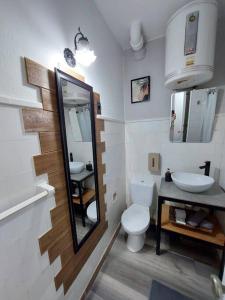 a bathroom with a sink and a toilet and a mirror at Edificio Punta del Este in Punta del Este