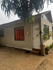 a small house with a tree in front of it at Cabañas San Joaquin in Isla Negra