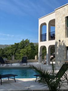 um edifício com piscina ao lado de uma casa em Villa Sani em Bribir