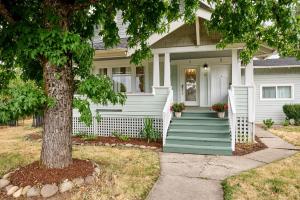 a white house with a green porch and a tree at Home - Elegant comfort 22 minutes to OSU in Lebanon