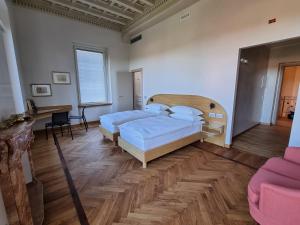 una camera con 2 letti e un pavimento in legno di Villa Hermann a Somma Lombardo