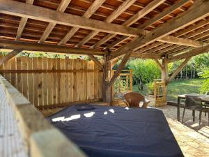 a wooden pavilion with a blue table in a patio at Le Domaine de la Claire Fontaine gites & chambres d'hôtes avec spas privatifs in Montvalent