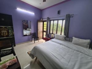 een slaapkamer met paarse muren en een groot bed bij Anukampa Paying Guest House in Agra