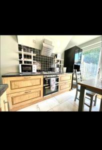 uma cozinha com um fogão e uma mesa em Vista homes em Roundhay