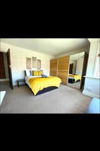 - une chambre avec un grand lit et une couverture jaune dans l'établissement Vista homes, à Roundhay