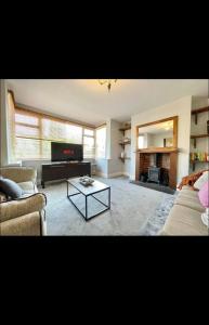 uma sala de estar com dois sofás e uma televisão em Vista homes em Roundhay