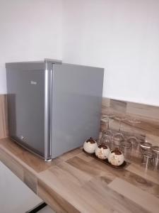 a stainless steel refrigerator sitting on a counter with two bowls at Nature Rock Dambulla in Dambulla
