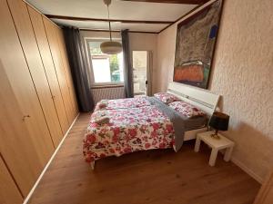 a bedroom with a bed with a red blanket and a window at ART House /15 Min. Düsseldorf Messe,Airport & City in Meerbusch