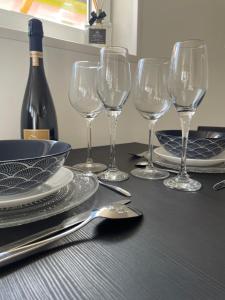 uma mesa com copos de vinho e uma garrafa de vinho em L agréable em Saint-Julien-les-Villas