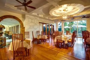 a restaurant with tables and chairs and a ceiling fan at San Ignacio Resort Hotel in San Ignacio