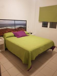 a bedroom with a green bed with a window at EL HOGAR DEL MAGEC in Las Palmas de Gran Canaria