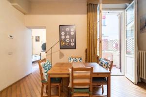 a dining room with a wooden table and chairs at Appartamento elegante e centrale La Foglia D'Oro in Bologna